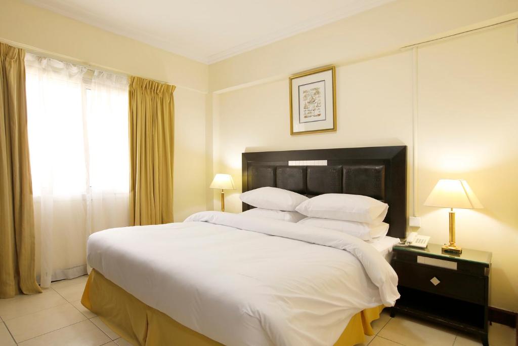 杜拜的住宿－Al Nakheel Hotel Apartments，卧室配有一张带白色床单和枕头的大床。