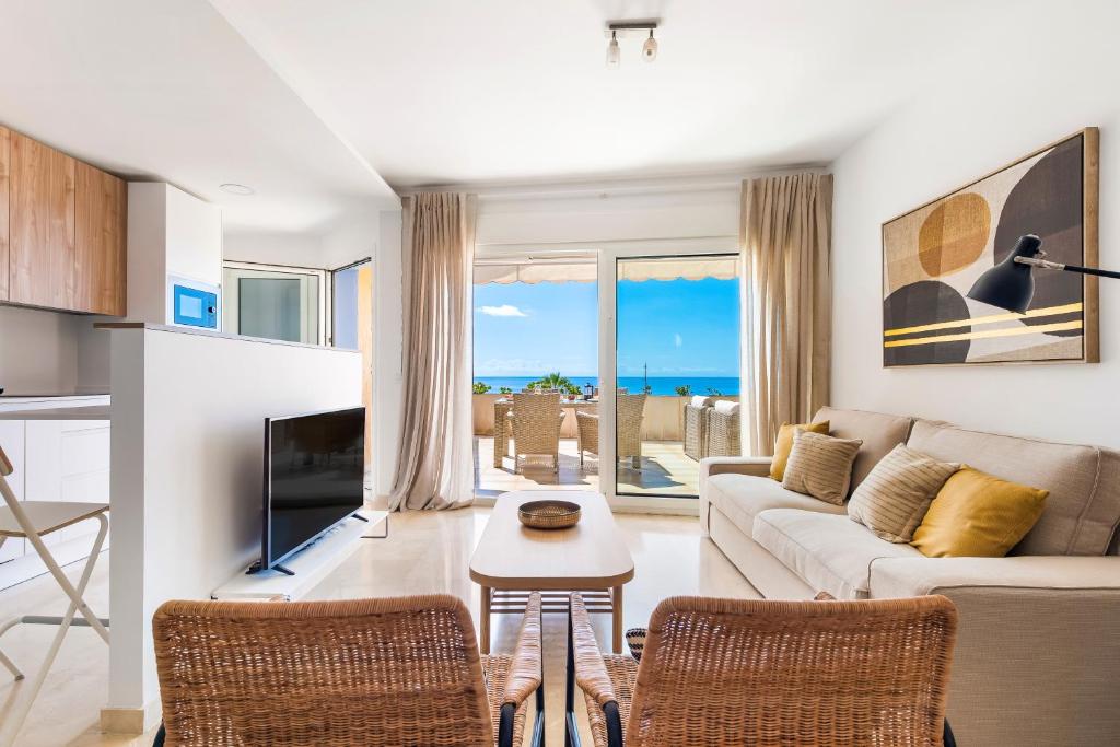 a living room with a couch and a table and chairs at Beach apartment with terrace and private parking in Radazul