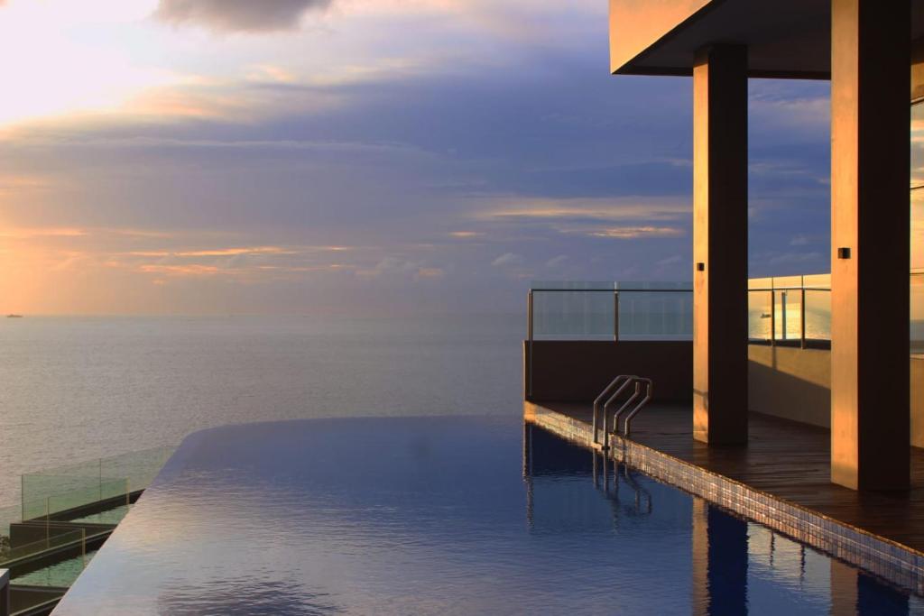 una piscina en la parte superior de un edificio con el océano en Golden Tulip Essential Belitung en Tanjung Pandan