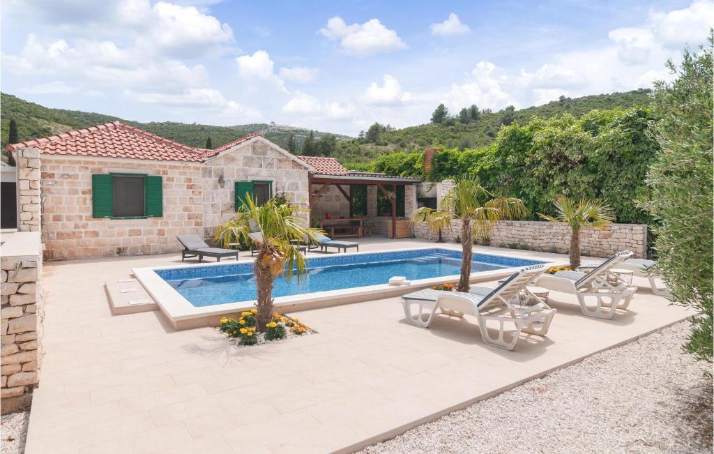 a villa with a swimming pool and a house at Awesome Home In Postira With Private Swimming Pool, Can Be Inside Or Outside in Postira
