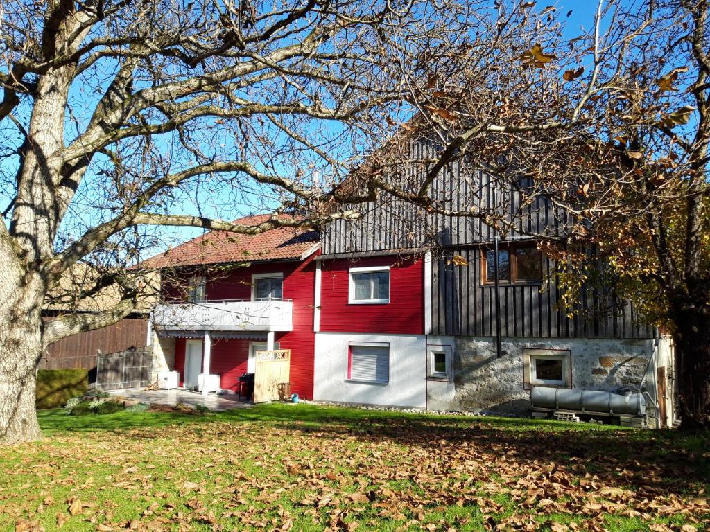 a red and white house with a tree at Ferienwohnung im Seidlerhof mit Terrasse in Röhrnbach