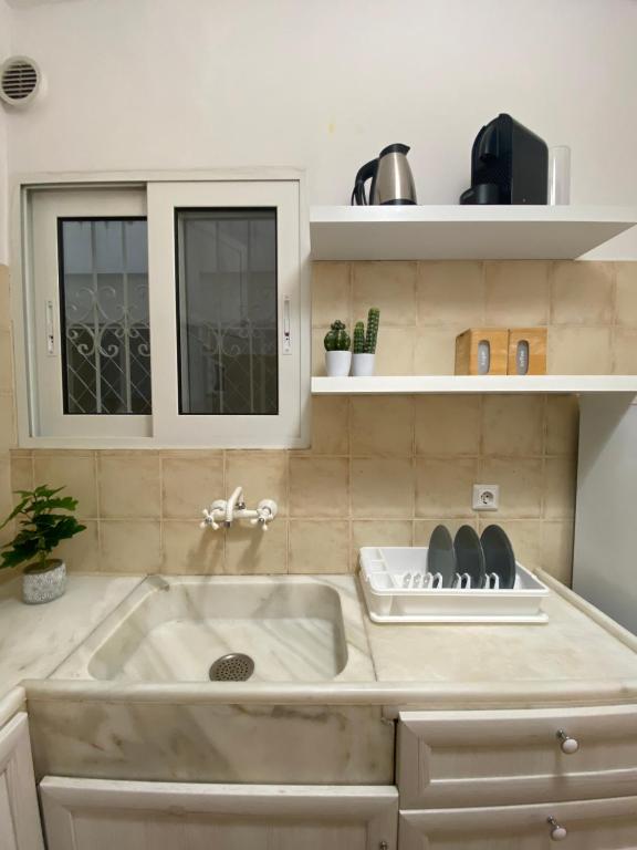 eine Küche mit einer Spüle und einer Arbeitsplatte in der Unterkunft Cozy Studio by the sea in Paleo Faliro in Athen