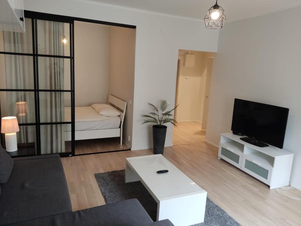 ein Wohnzimmer mit einem Sofa und einem TV in der Unterkunft Adorable Central Apartment Helsinki in Helsinki