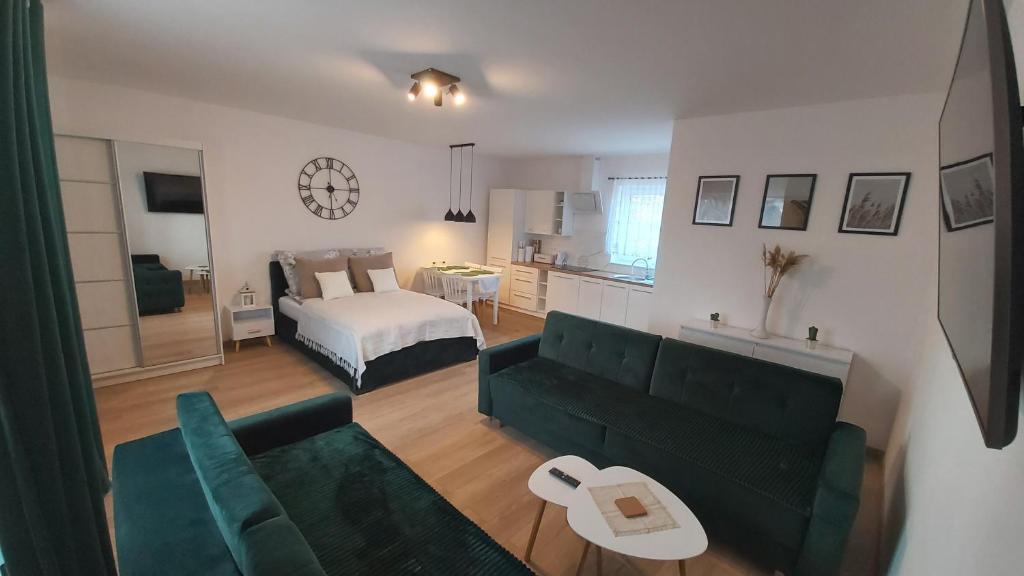 a living room with a couch and a bed at Apartament Szmaragdowy in Dąbki