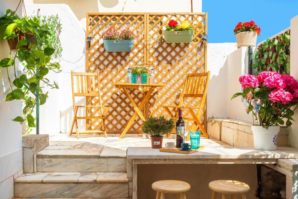 a patio with two chairs and a table with flowers at Happy Holiday Cascais - Garden in Cascais