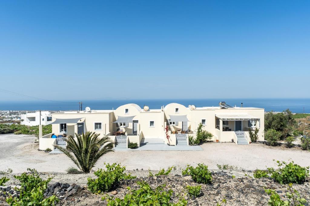 duży biały dom z oceanem w tle w obiekcie Ampelos Executive Houses w mieście Pirgos