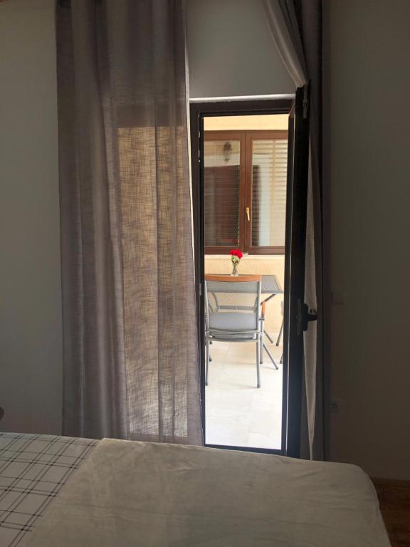 a bedroom with a bed and a view of a table at Apartman ANA in Vrlika