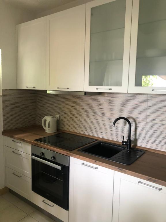 a kitchen with white cabinets and a sink at Apartman ANA in Vrlika