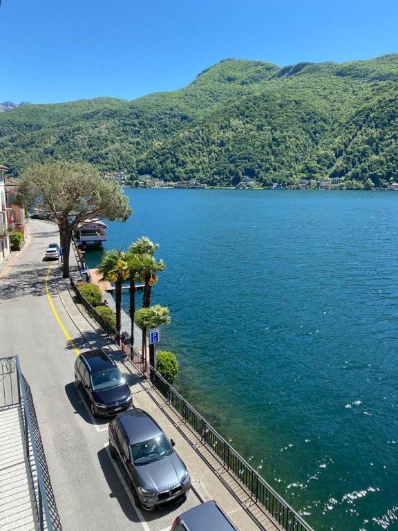 two cars parked on a street next to a body of water at Apartment in erster Seelinie in Morcote in Morcote