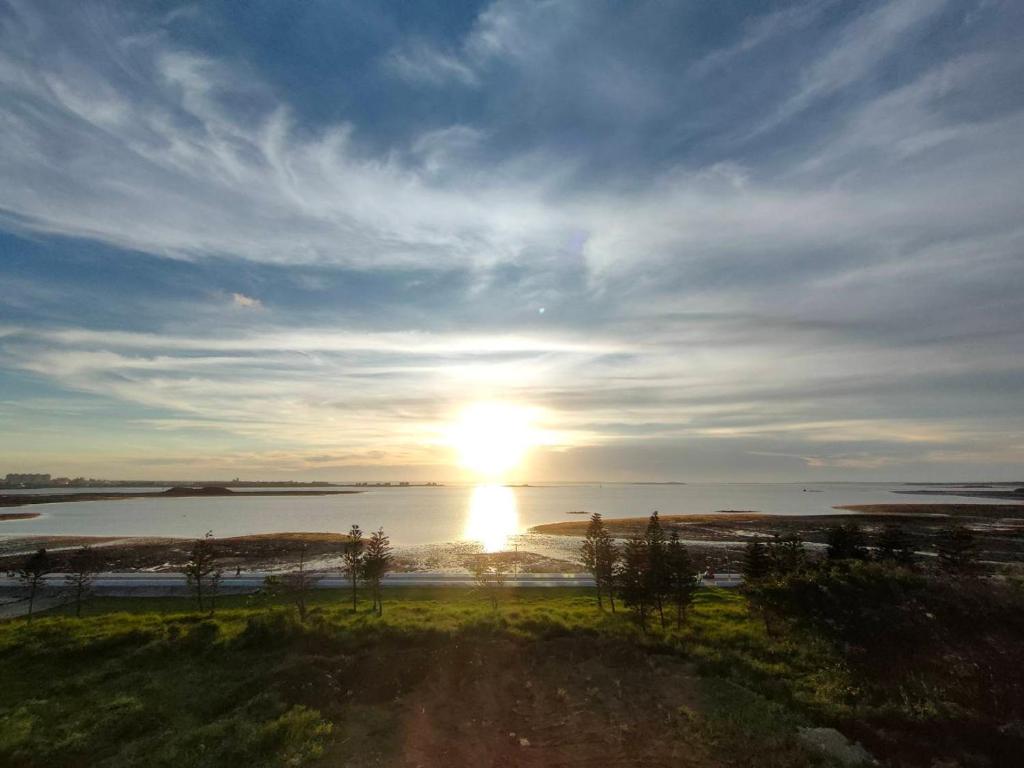 a sun setting over a body of water at Travel Time Homestay in Huxi