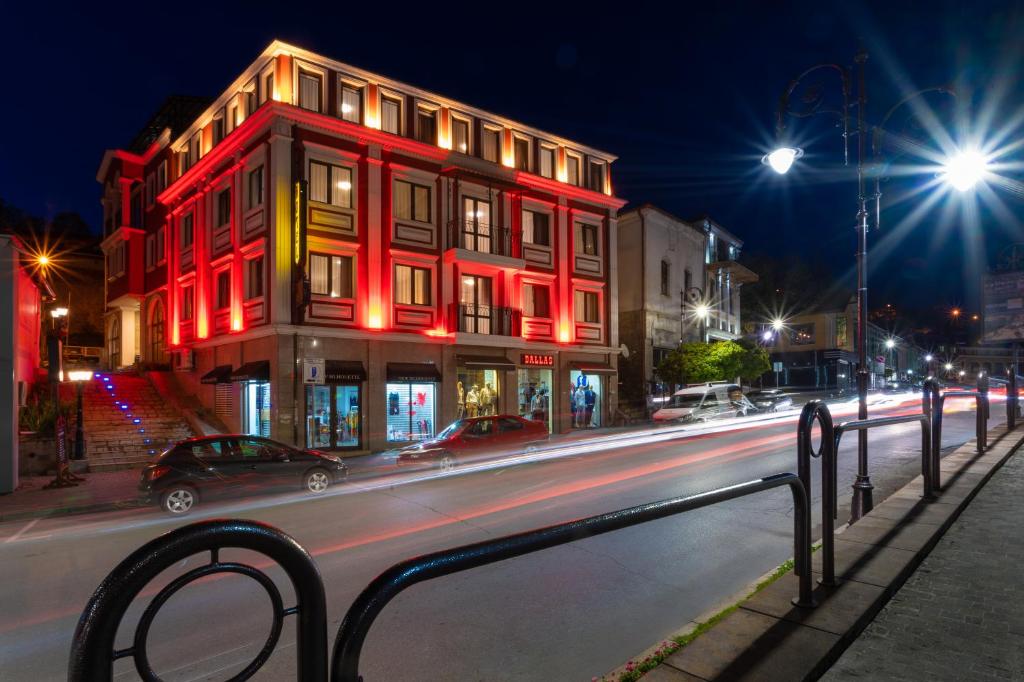 a red building on a city street at night at Real Hotel in Veliko Tŭrnovo