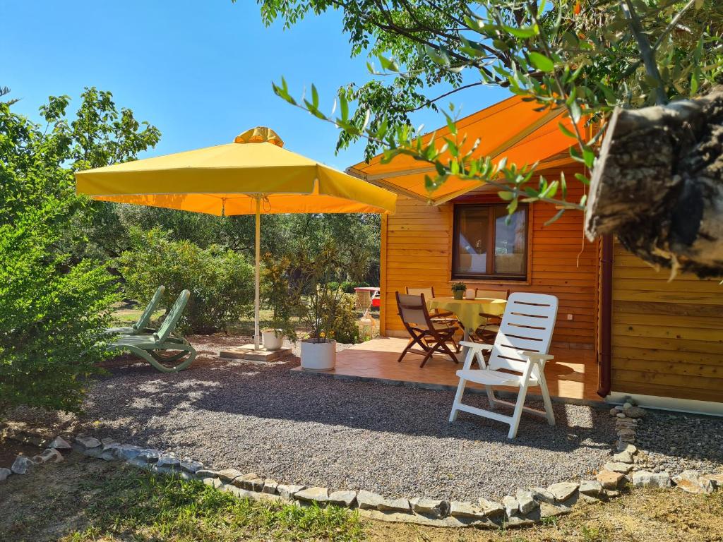eine Terrasse mit einem Sonnenschirm, einem Tisch und Stühlen in der Unterkunft Ktirakia Studios in Gythio