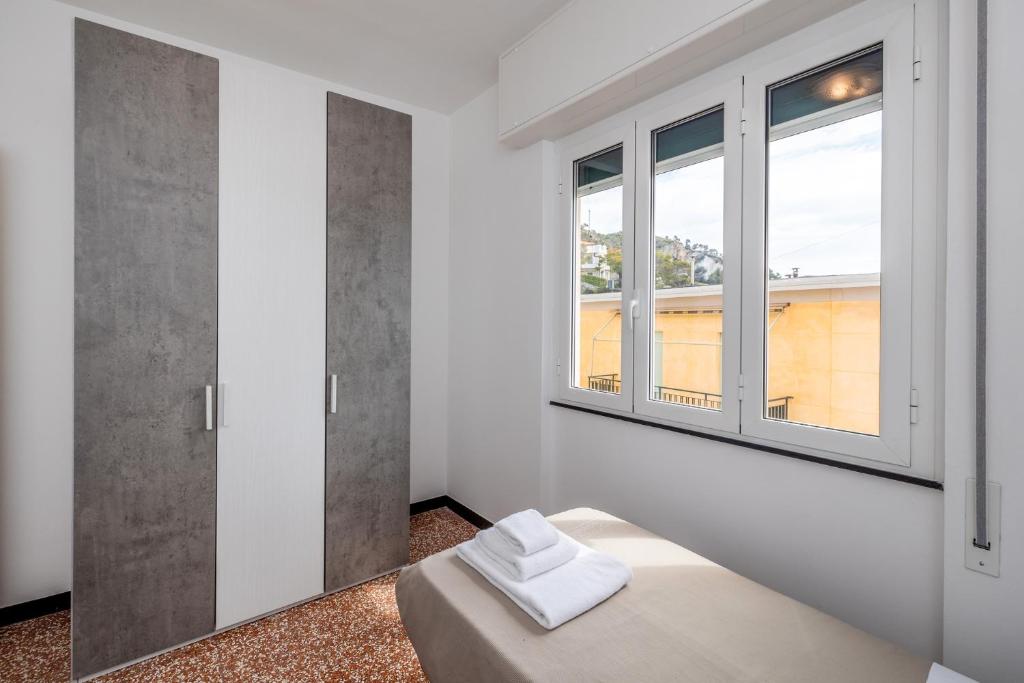 a white room with a bed and two windows at Le Casasse "Paradiso" in Varigotti
