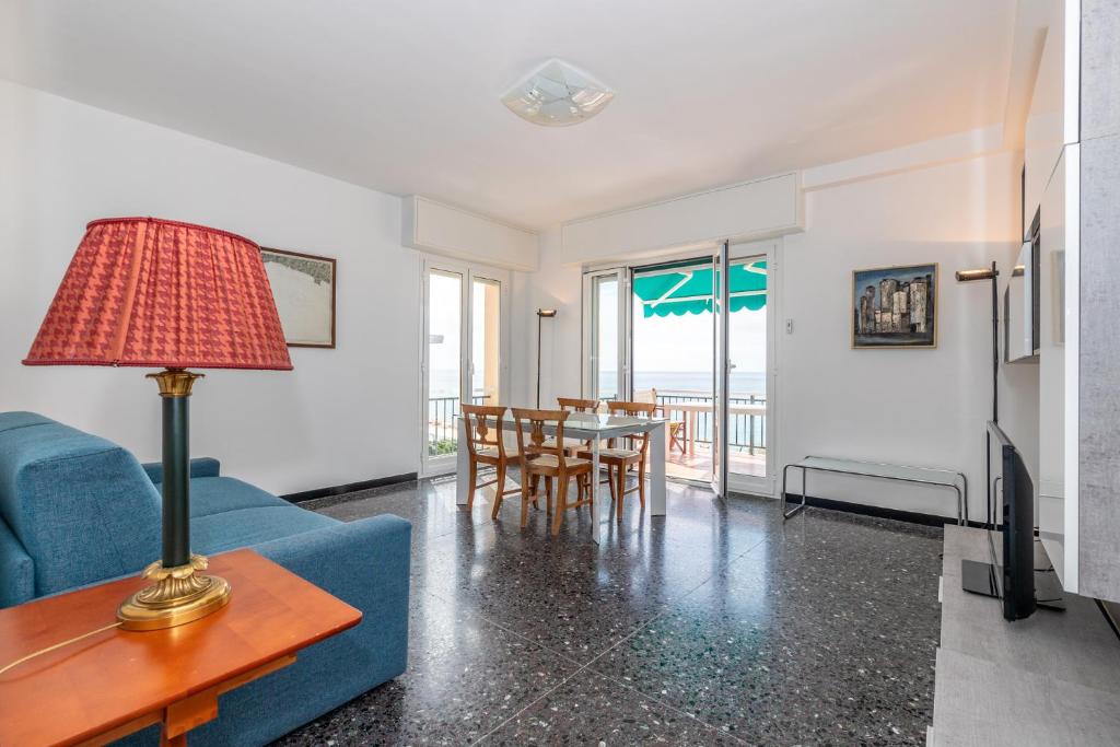 a living room with a blue couch and a table at Le Casasse "Paradiso" in Varigotti