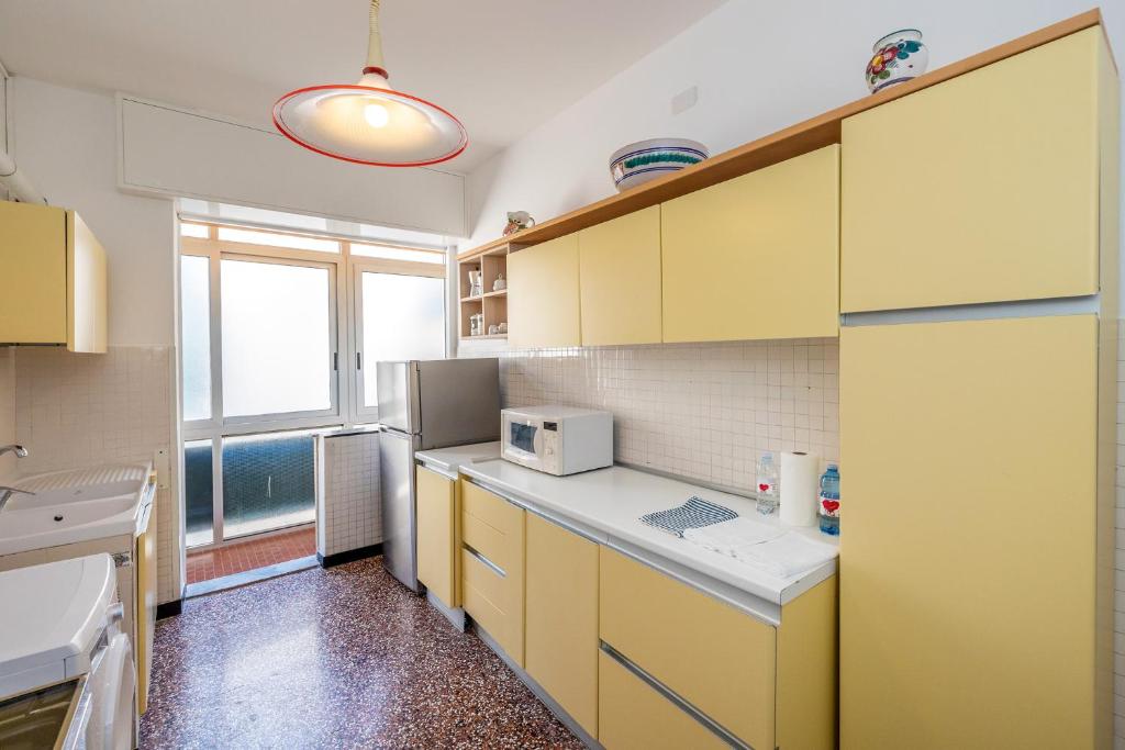a kitchen with yellow cabinets and a microwave at Le Casasse "Paradiso" in Varigotti