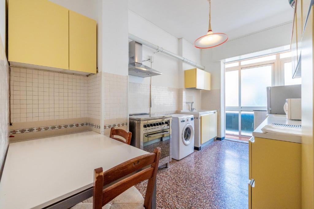 a kitchen with yellow cabinets and a washer and dryer at Le Casasse "Paradiso" in Varigotti