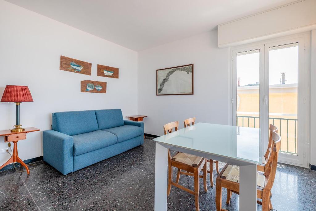 a living room with a blue couch and a table at Le Casasse "Paradiso" in Varigotti
