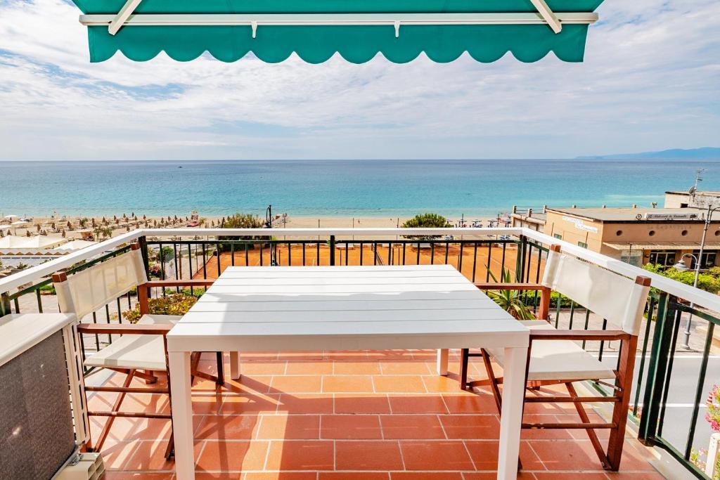 a white table and chairs on a balcony with the beach at Le Casasse "Paradiso" in Varigotti