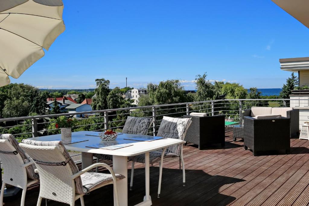 a patio with a table and chairs on a balcony at Villa Sanddorn Wohnung 16 in Börgerende-Rethwisch