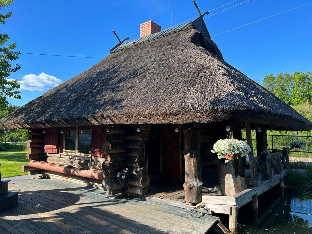 a log cabin with a thatched roof at Pirtiņa in Ogre