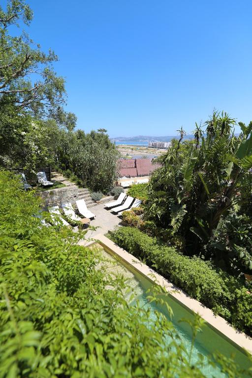 a view of a beach with lounge chairs and a pool at Mimi Calpe in Tangier