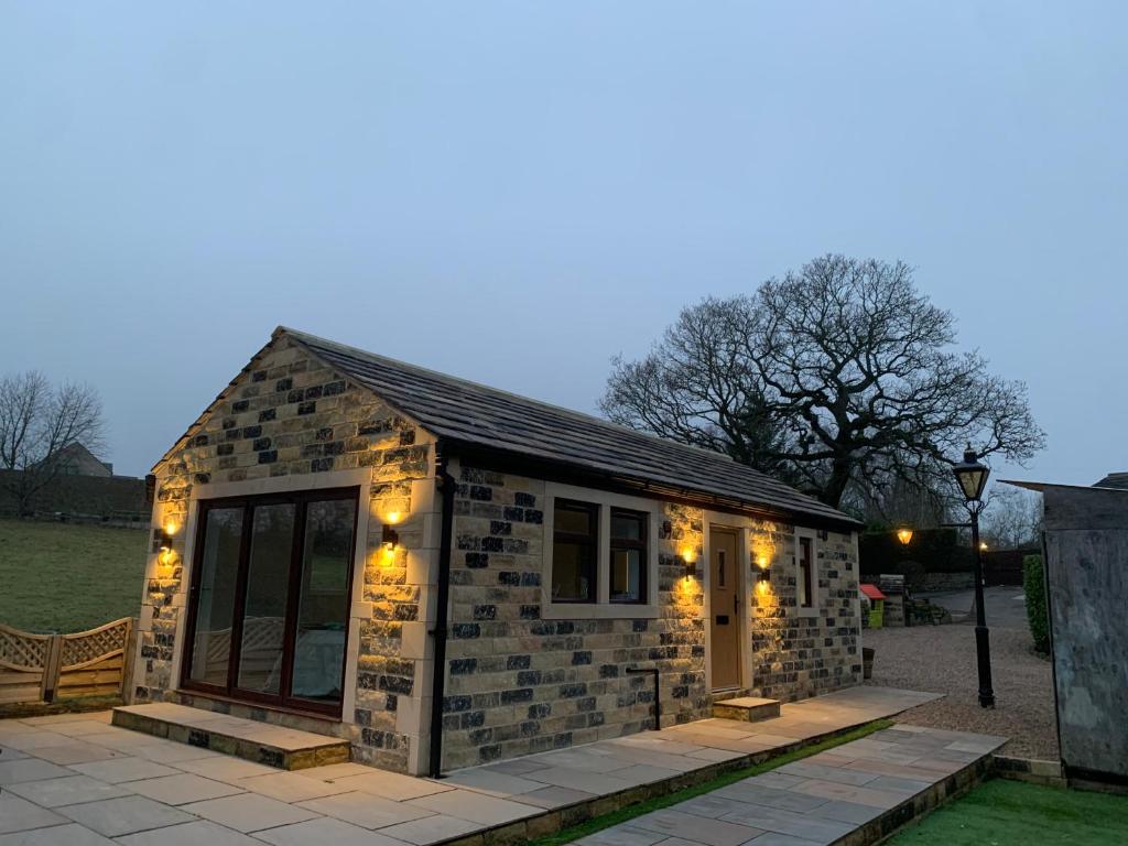 una pequeña casa de piedra con luces encendidas en Brand new purpose built annex :- The Stables, en Halifax