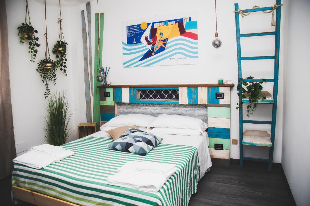 1 dormitorio con 1 cama con manta a rayas en Homiday - Bel Salento Specchia, en Specchia