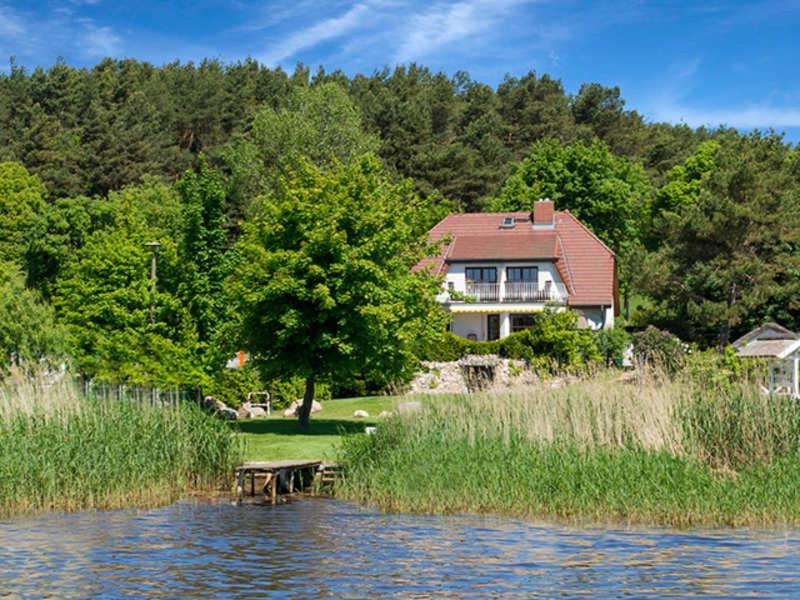 ein Haus auf der Seite eines Wasserkörpers in der Unterkunft Selliner Ferienappartements mit Balkon und Seeblick in Ostseebad Sellin