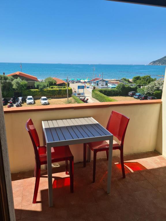 a table and chairs on a balcony with a view of the ocean at LunaMarina in Marinella di Sarzana