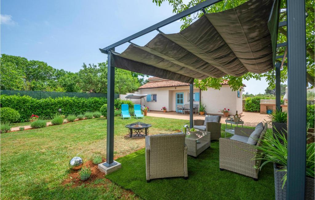 a pergola with chairs and a table in a yard at 2 Bedroom Stunning Home In Sisan in Šišan