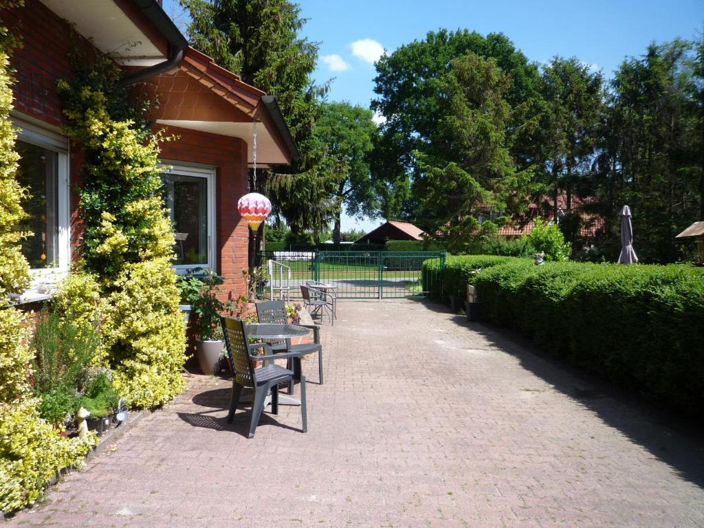 a group of chairs and tables on a brick walkway at Ferienzimmer Alte Kämpe in Heede