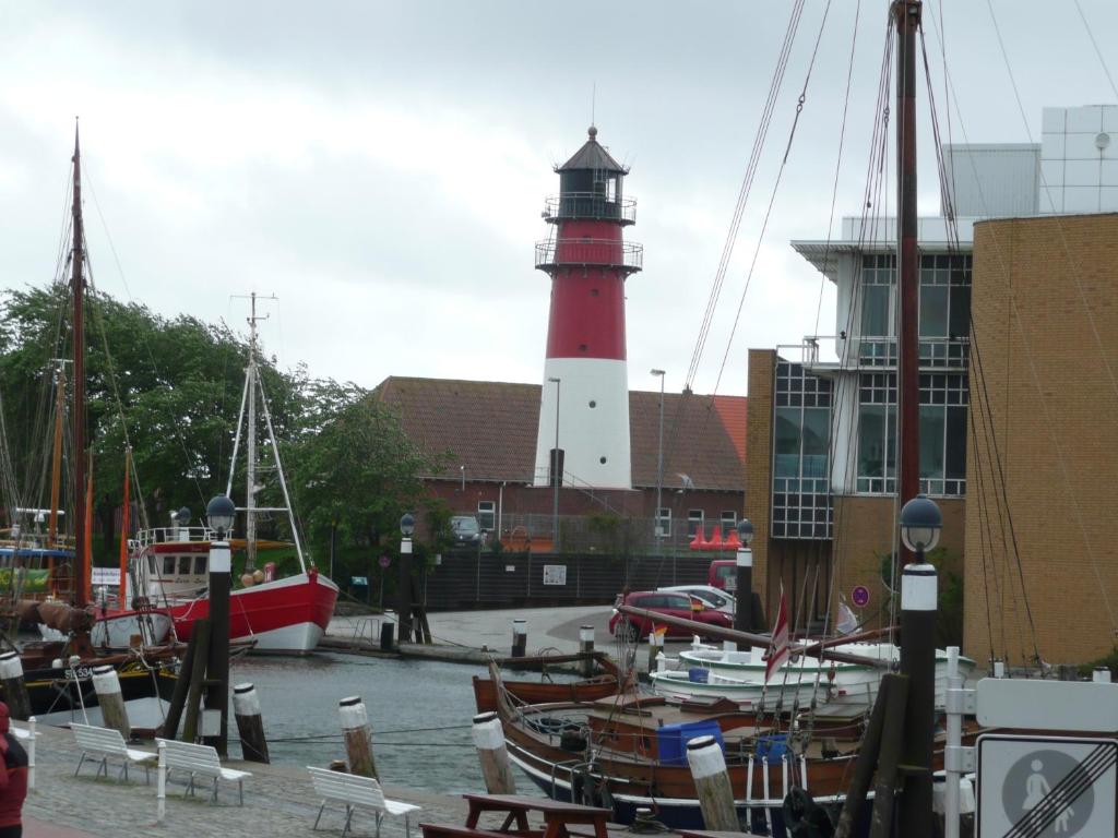un faro rojo y blanco con barcos en un puerto en Apartment Ahoi, en Büsum
