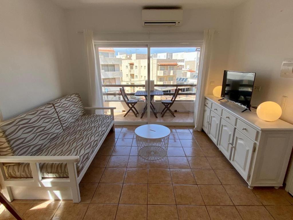 uma sala de estar com um sofá, uma televisão e uma mesa em Apartamento para 4-5 personas en es Pujols, Formentera em Es Pujols