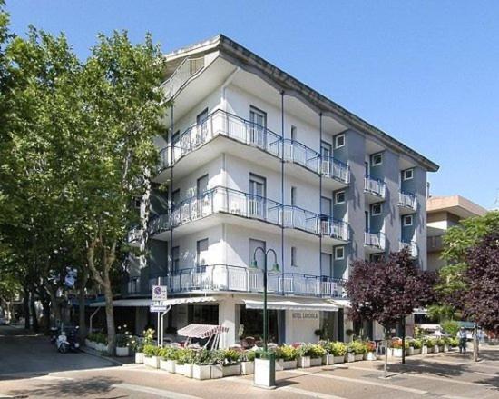 ein großes weißes Gebäude mit Balkon auf einer Straße in der Unterkunft B&B Hotel Lucciola in Cattolica