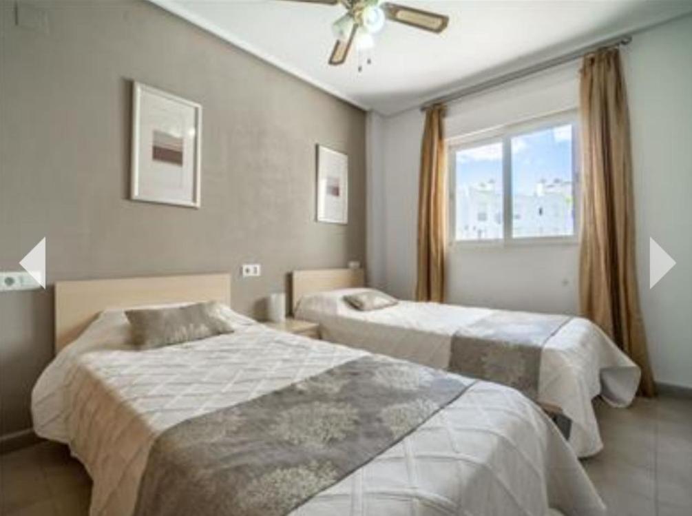 1 dormitorio con 2 camas y ventana en Casa Gavendy, La Torre Golf Resort en Murcia