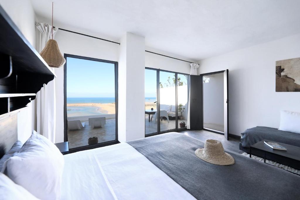 a bedroom with a bed with a view of the ocean at El Manzar in Oualidia