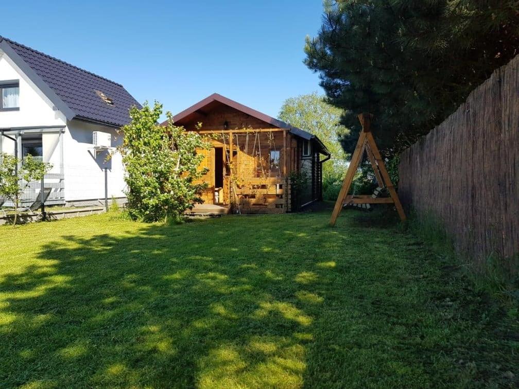 a small house in a yard with a fence at Domek letniskowy Zacisze pod Sosnami Trzęsacz in Trzęsacz