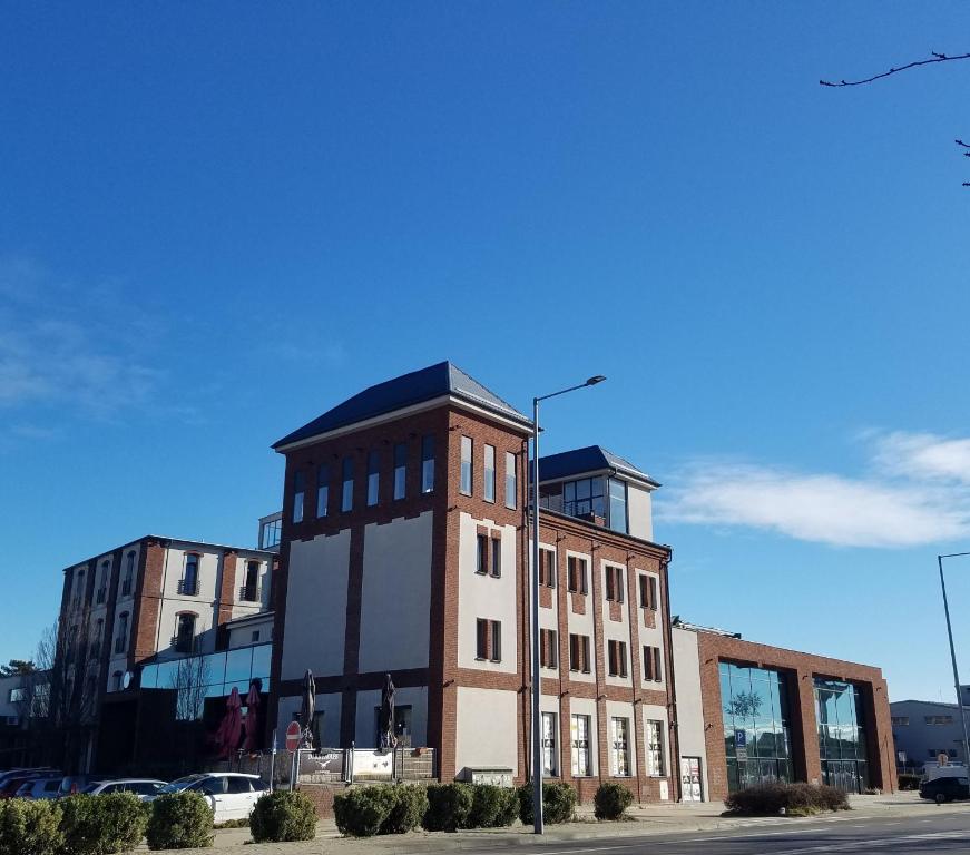 a large brick building on the corner of a street at Arena Hotel Samorin in Šamorín