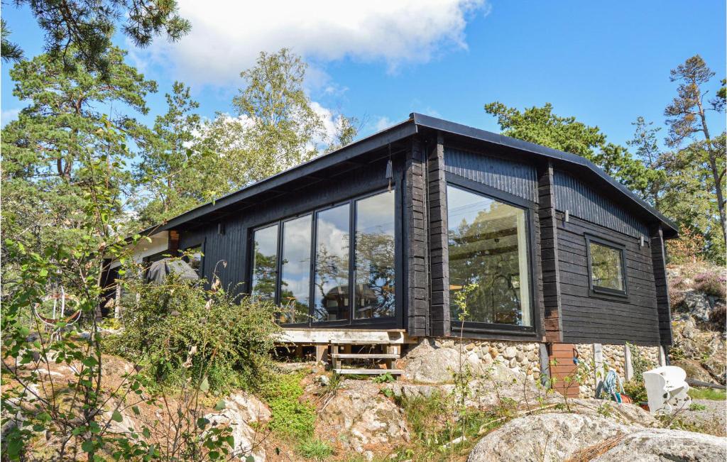 een zwart huis op een heuvel met bomen bij Stunning Home In Sorunda With Wifi And 2 Bedrooms in Grytnäs