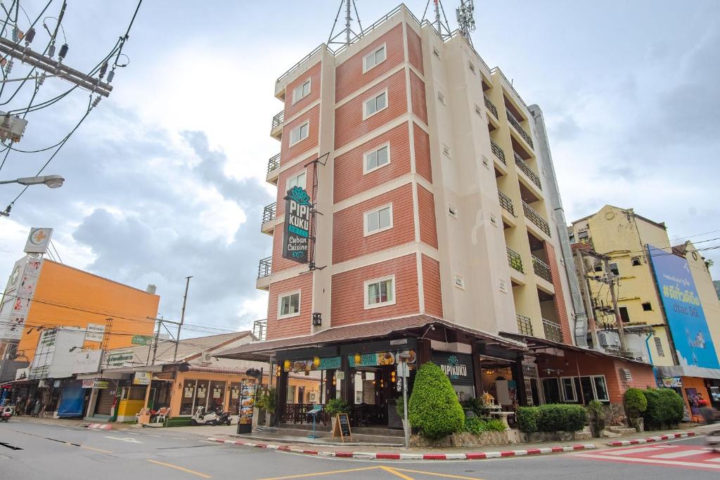 ein hohes Gebäude an der Ecke einer Straße in der Unterkunft Pipikuku Hotel & Restaurant in Patong Beach