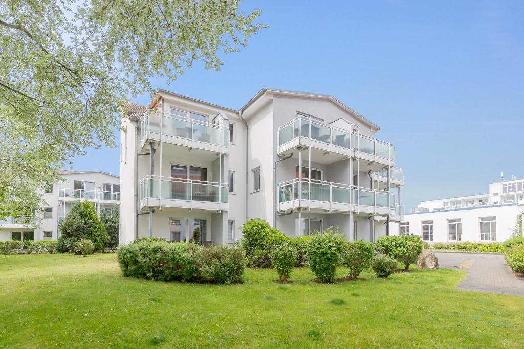 an apartment building with a lawn in front of it at Yachthafenresidenz in Kühlungsborn