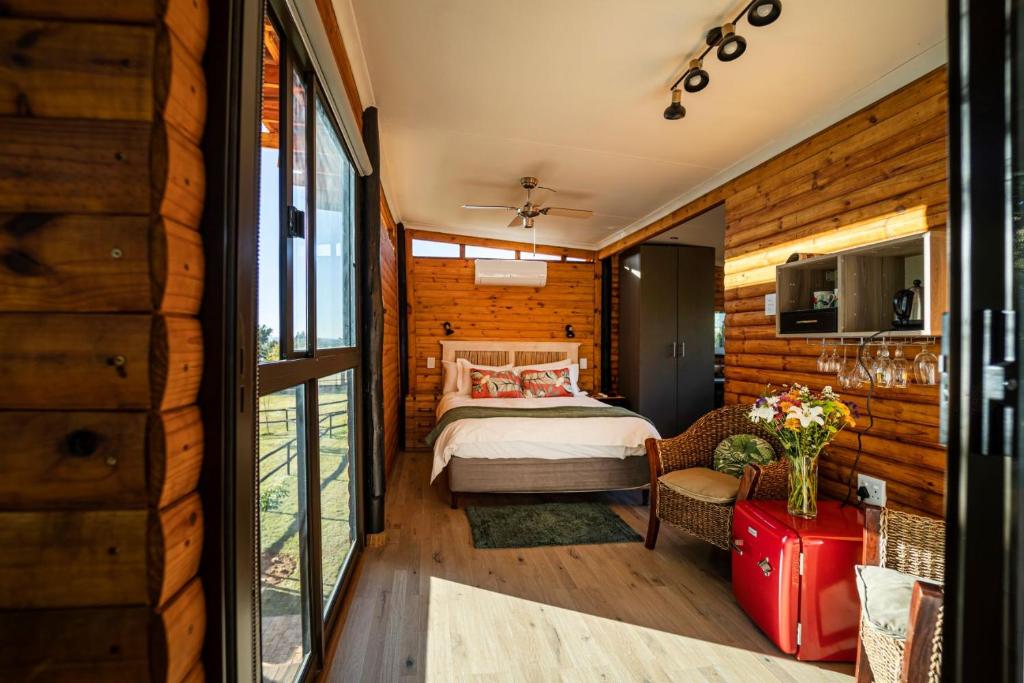 a bedroom in a log cabin with a bed at Windsong Living The Nest in Krugersdorp
