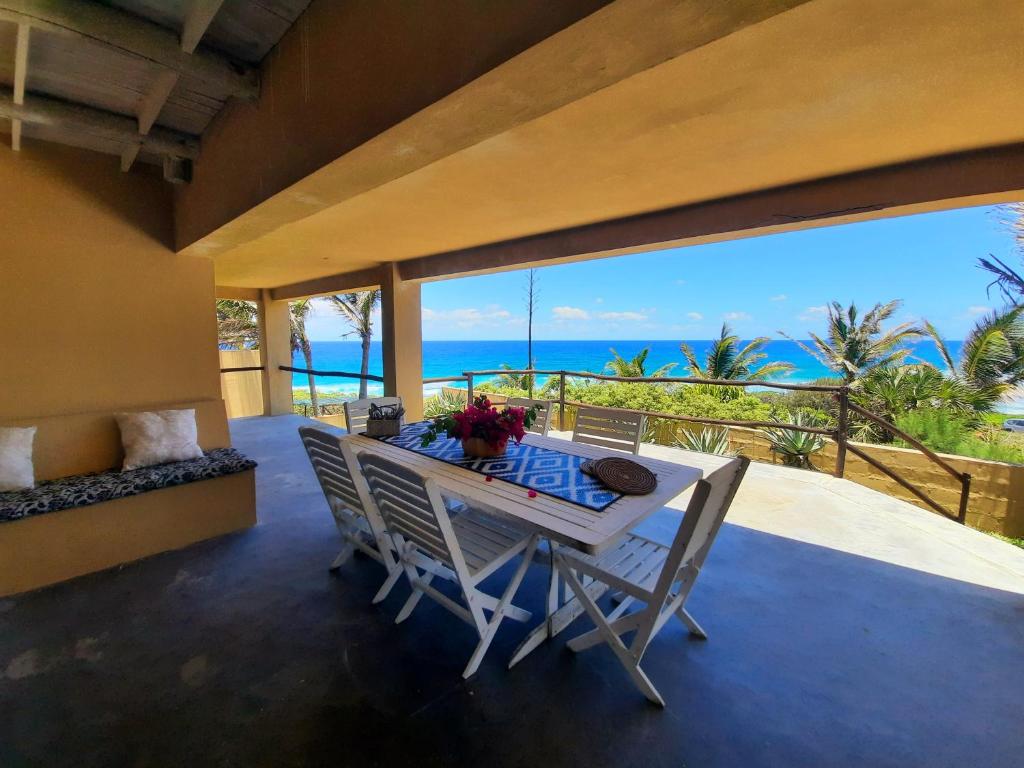 a dining room with a table and a view of the ocean at Casa Malcampo in Praia do Tofo