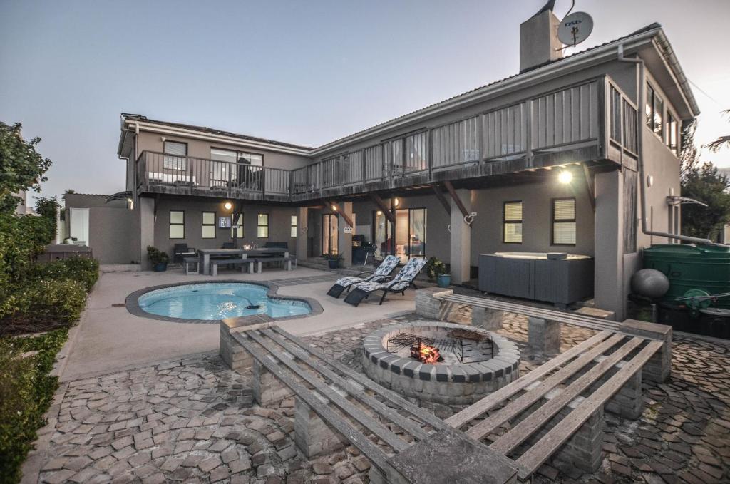 a house with a pool and a fire pit at Sunset Villa in Yzerfontein