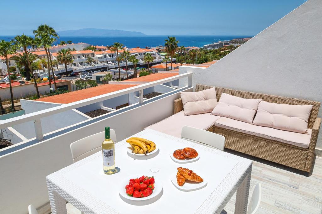 a balcony with a table with food and a bottle of wine at Lovely Sea View FREE WIFI in Adeje