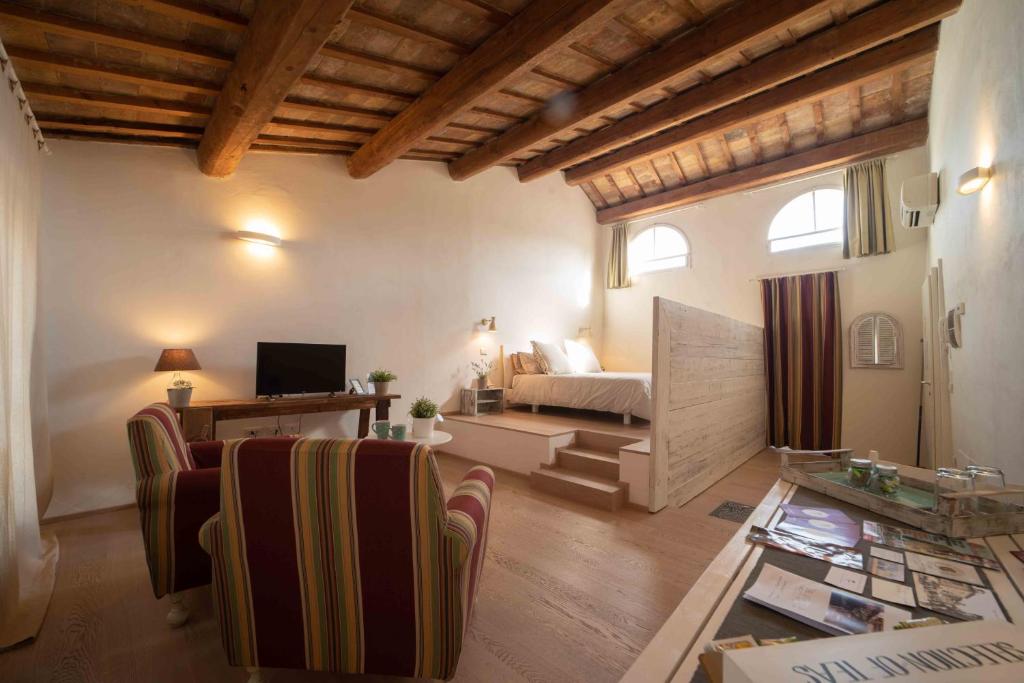 een woonkamer met een bed en een tafel en stoelen bij B&B Relais Druda in Cagli