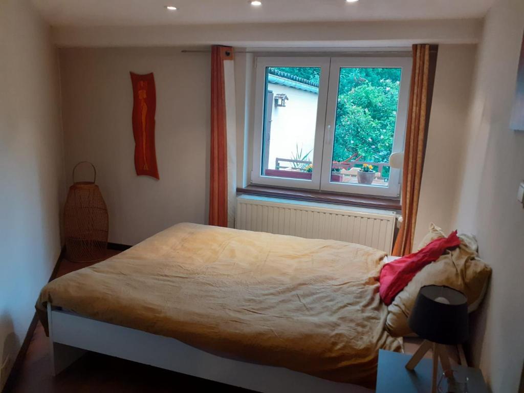sypialnia z łóżkiem i oknem w obiekcie À la pause bien méritée =) w mieście Villers-la-Ville