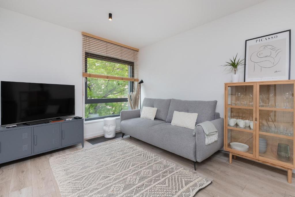 a living room with a couch and a flat screen tv at Awanport Estate Gdynia by Renters in Gdynia
