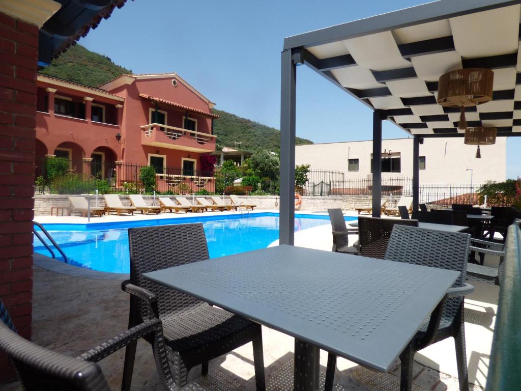 uma mesa e cadeiras ao lado de uma piscina em Villa Sofia em Ipsos