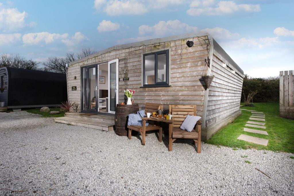 a tiny house with a table and two chairs at Wheal Rose -Beautifully Fitted Lodge Helston Cornwall in Helston